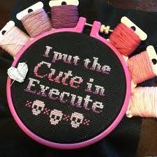 some spools of thread sitting on top of a black cloth with the words i put the cute in execute