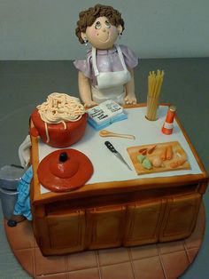 a cake shaped like a woman cooking pasta on a kitchen counter with utensils