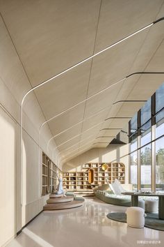 the interior of a modern library with bookshelves and circular seating area in front of large windows