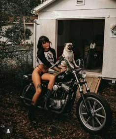 a woman sitting on a motorcycle with a pug in the back seat next to her