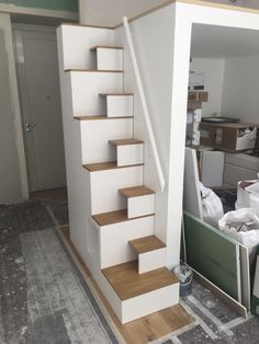 the stairs are painted white and have wood treads on them in an unfinished room