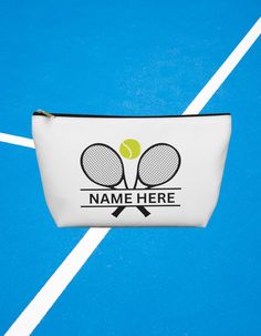 a tennis ball and racket on a blue court with the name here printed on it