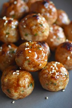 some meatballs with sesame seeds and seasoning on them