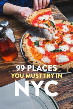 a person is cutting into a pizza on a wooden table with the words 99 places you must try in nyc