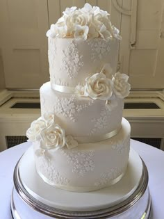 a three tiered white wedding cake with flowers on it