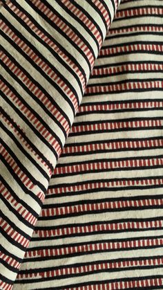 red and black striped fabric with small white dots on the bottom right half of it