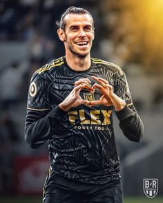 a soccer player is making a heart with his hands