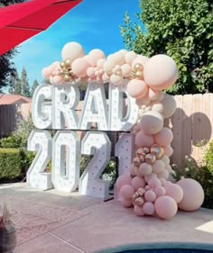 a large balloon arch with the word graduation in front of it and balloons on top