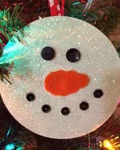 a snowman ornament hanging from a christmas tree