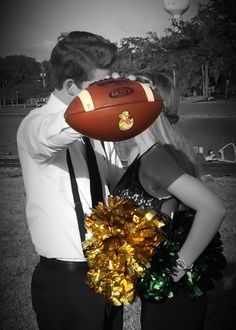 a man and woman kissing while holding a football