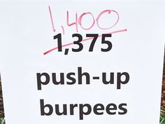 a sign that says push - up burpees is posted in front of some grass