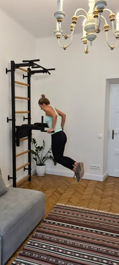 a woman jumping in the air near a gym equipment