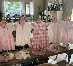 baby clothes and shoes are on display in a room with pictures hanging from the walls