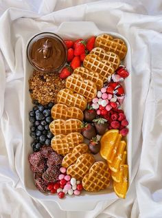 a white plate topped with waffles and fruit