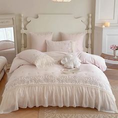 a white bed sitting in a bedroom next to a window with curtains and pillows on top of it