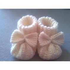 a pair of crocheted baby shoes with bows