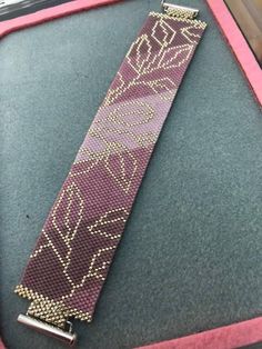 a pink and gold watch band sitting on top of a table