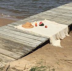 a picnic on the beach with watermelon and strawberries laid out on it