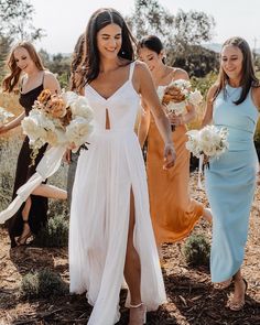 the bridesmaids are all wearing different colored dresses and holding bouquets in their hands