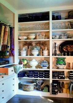 an open pantry filled with lots of different types of dishes and utensils on shelves