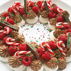 a white plate topped with a cake covered in frosting and candy canes