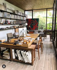 a room filled with lots of furniture and bookshelves next to a wooden floor