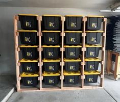 several bins are stacked up on wooden shelves in a storage room with yellow and black containers