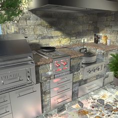 an outdoor kitchen with stone counters and grills, potted plant on the counter