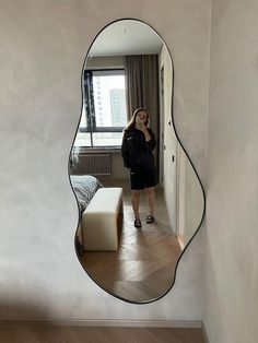 a woman taking a selfie in front of a mirror with her reflection on the wall