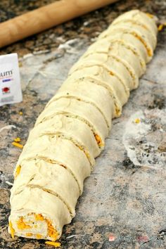 an uncooked pastry sitting on top of a counter next to a rolling pin