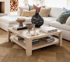 a living room with a white couch and coffee table in front of a fire place