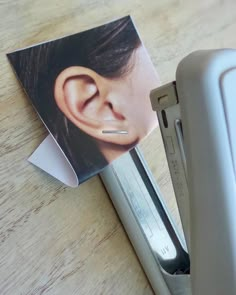 a pair of ear piercings sitting on top of a piece of paper next to an electronic device