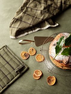 a cake with icing and orange slices sitting on a plate next to a towel