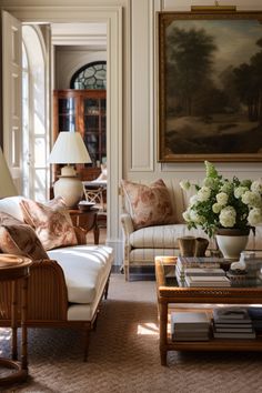 a living room filled with lots of furniture and flowers in vases on the coffee table