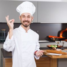 a man in a chef's outfit is holding his hand up to the camera