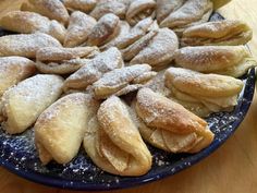 a blue plate topped with pastries covered in powdered sugar