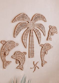 the palm tree is made out of wicker and has dolphins in front of it