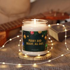 a white candle sitting on top of a table next to a string of christmas lights