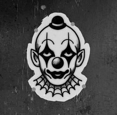 a black and white photo of a sticker with a clown's face