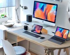 two laptops and a desktop computer on a desk