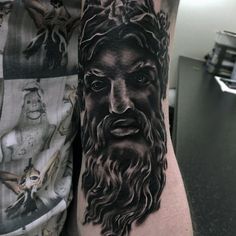 a man's arm with a black and grey portrait of jesus on the side