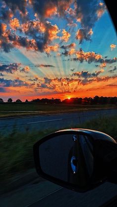 the sun is setting behind clouds in the sky