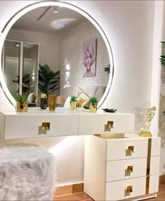 a white vanity with gold handles and drawers in front of a round mirror on the wall