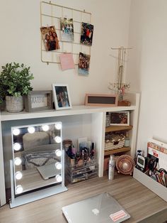 a desk with a laptop, mirror and lights on it