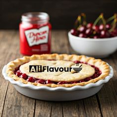 a pie sitting on top of a wooden table next to a bowl of cherries