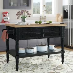 a kitchen island with pots and pans on it in the middle of a room