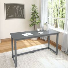 an office desk in front of a window with a potted plant next to it