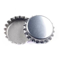 two silver bottle caps sitting next to each other on a white surface with no background