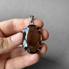 Smoky Quartz Pendant - Large Smoky Quartz Necklace - Quartz Pendant - Smoky Quartz Jewelry - Quartz - Sterling Silver and Smoky Quartz Gemstone: Natural Smoky Quartz Metal: 925 Sterling Silver Stone Cut: Faced Stone Size: 40.8 mm x 26.6 mm - 1.60 in x 1.04 in Pendant Size: 55.5 mm x 26.6 mm - 2.18 in x 1.04 in Weight: 25 grams (125 carats ) total weight of stone and metal.  For ring orders, ring resizing is free.  Chains are gifts for necklace orders..  Note: We don't use any filters for photos. The details may not be clear. Feel free to contact us with any questions, special orders or additional photo or video requests. We will be happy to provide more information! :) WORLDWIDE FedEx, UPS or TNT EXPRESS MAIL SERVICE (Delivery time: 1 - 5 business days.) LAYAWAY PAYMENT PLAN is available. Luxury Smoky Quartz Engagement Jewelry, Smoky Quartz Jewelry, Smoky Quartz Necklace, Smoky Quartz Pendant, Quartz Jewelry, Payment Plan, Stone Cuts, Quartz Pendant, Quartz Necklace