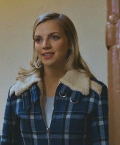 a woman wearing a blue and white plaid jacket